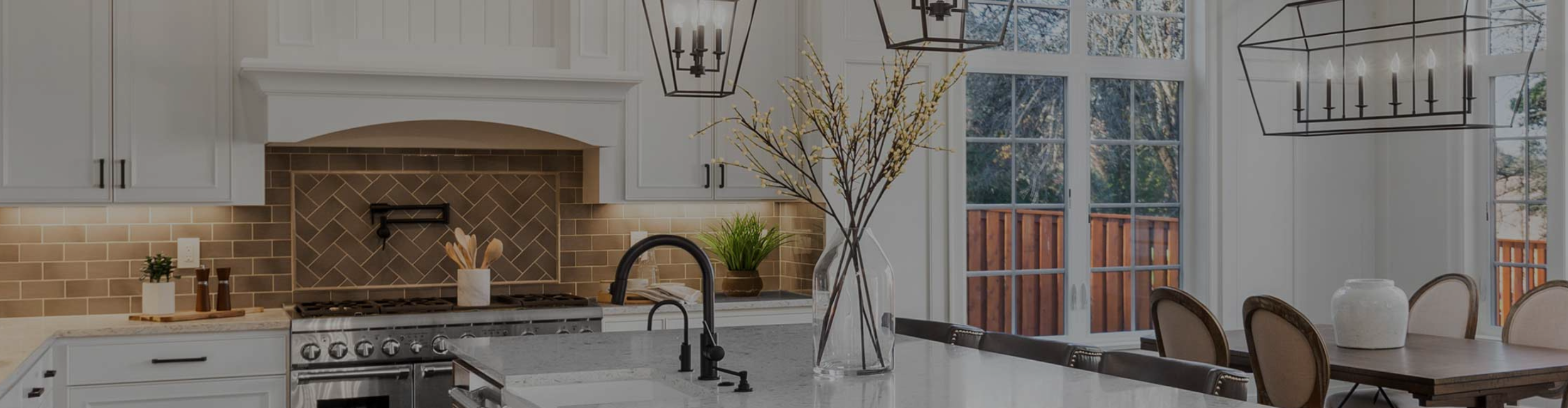 kitchen with white cabinetry, a dark wood island, and a herringbone-patterned golden-brown backsplash. Features include a farmhouse sink, stainless steel appliances, and warm under-cabinet lighting